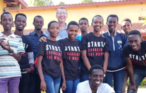 David Kosbie stands with a group of Rwandan students