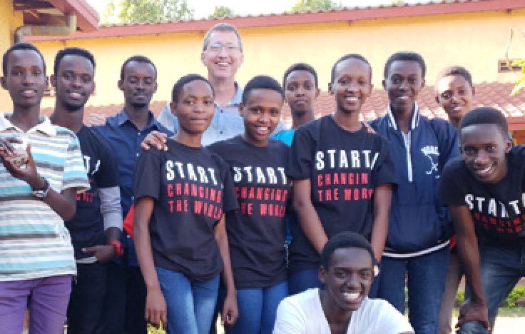 David Kosbie stands with a group of Rwandan students