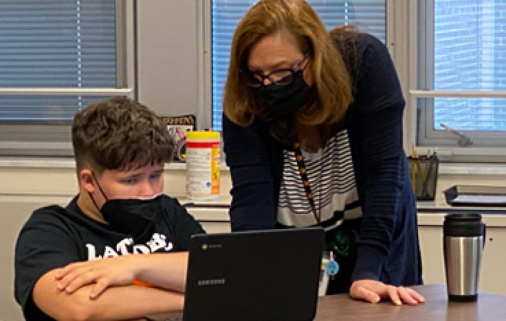 Wendy Lint and a student look at work on a laptop